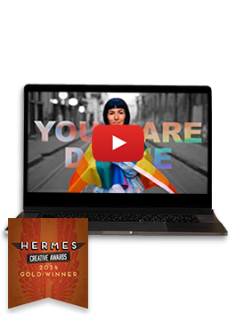 An open black laptop with a video still featuring a person wrapped in a rainbow flag - Hermes Creative Awards 2024 Gold Winner